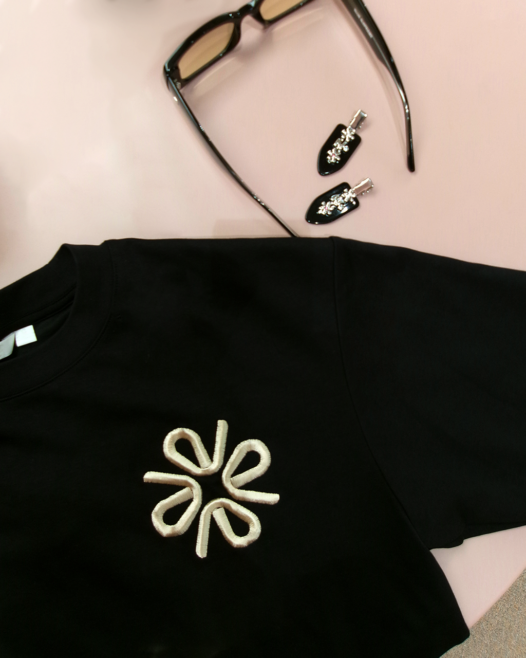 Black t-shirt with a white floral embroidery design.